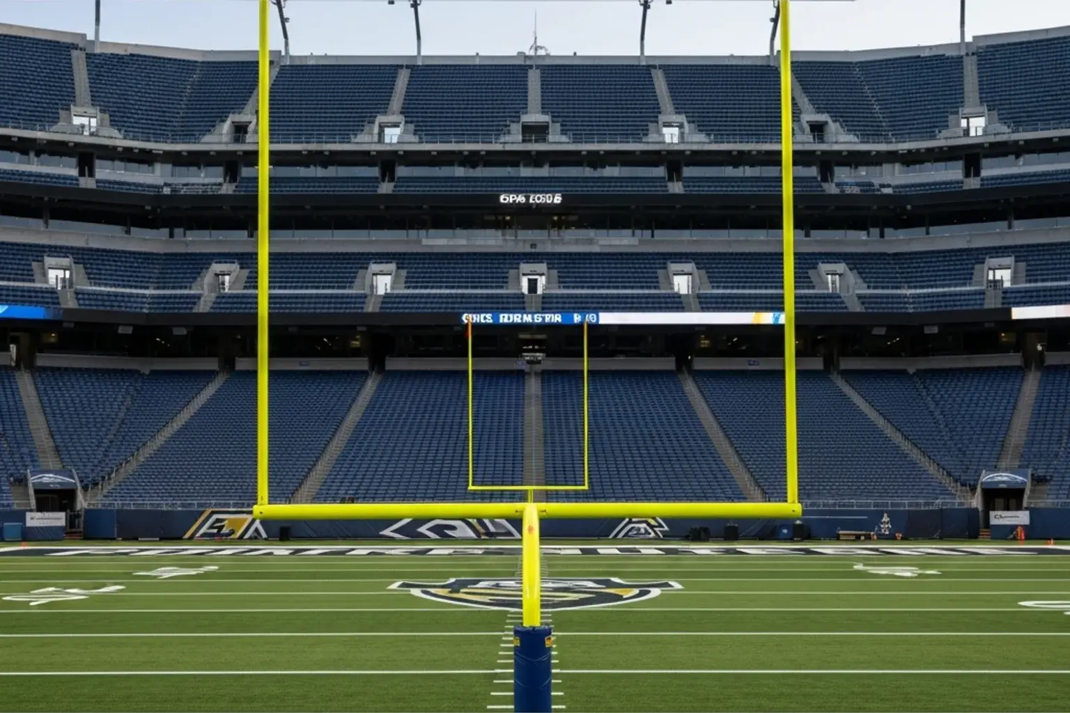 Empty American football stadium seating bowl viewed from the pitch in early evening